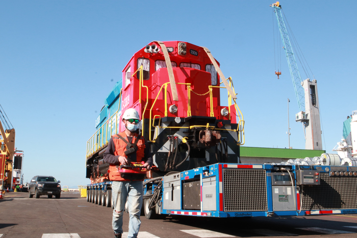 Worker walking alongside locomotive being moved on an smpt.