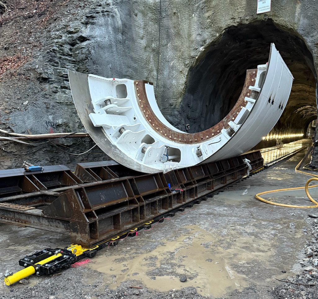 A portion of a tunnel boring machine is shown on a Low-Height Skidding System just outside of a tunnel.