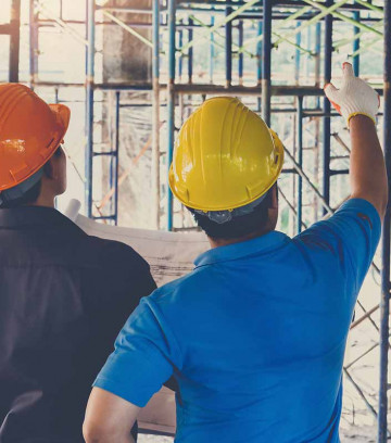 Engineer-discussing-with-foreman-about-project-in-building-construction-site-1048362958_1416x2125-sq